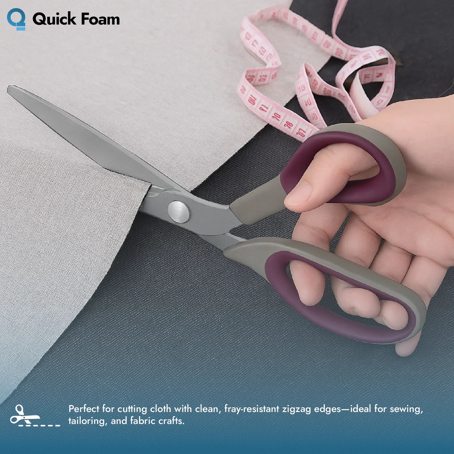 Hand using Hemline Pinking Scissors to cut a edge on light grey fabric, with a measuring tape nearby.