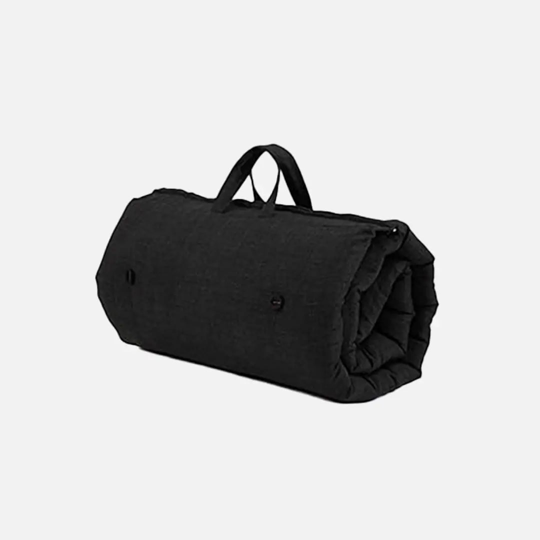 Black, rolled-up indoor/outdoor sleepover mattress with a carry handle.