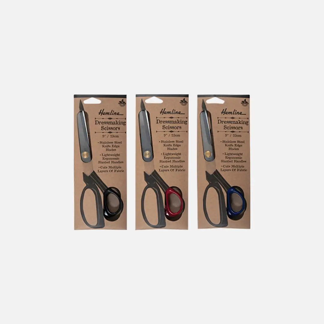 Three packages of Hamline Dressmaking Scissors with black, red, and blue ergonomic handles displayed.